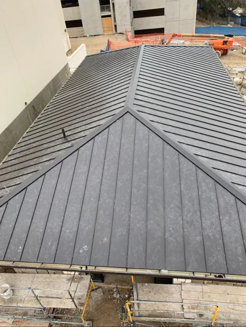 Commercial metal roof construction with crane equipment in New Castle